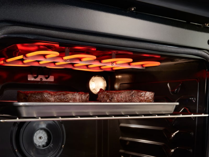 Meat broiling under broiling element in an oven
